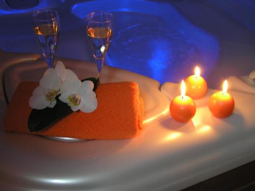 a table with two glasses and candles and flowers on it at Boutique Hotel Loka in Škofja Loka
