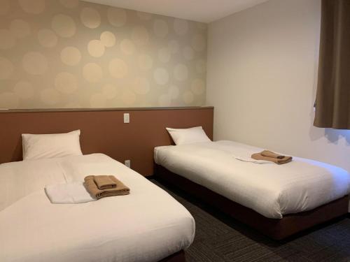 two beds in a hotel room with towels on them at HOTEL IL GRANDIT - Vacation STAY 46772v in Sakai