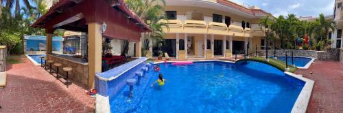 a large swimming pool in front of a house at Hotel Vista Caribe 5ta Av a 5 Pasos de la Playa in Playa del Carmen