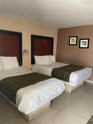 two beds in a hotel room next to each other at Hotel Flamingo in Ciudad Juárez
