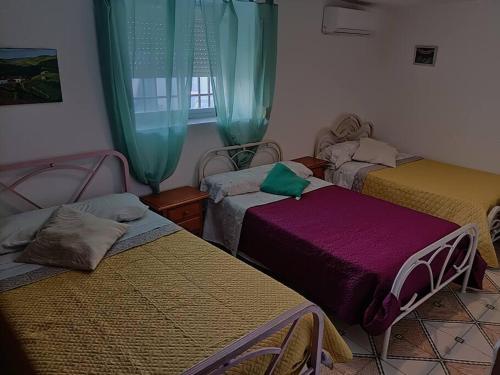 a room with three beds and a window at LA CASA DE LOS LIRIOs in Alcabón