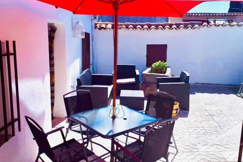 a table and chairs with an umbrella on a patio at LA CASA DE LOS LIRIOs in Alcabón