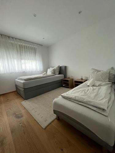 a bedroom with two beds and a window at PanoramaVista in Hof bei Salzburg
