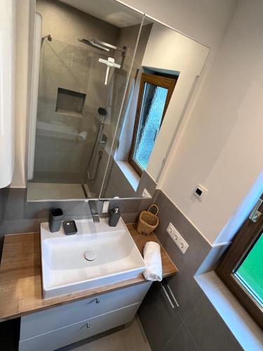 a bathroom with a white sink and a shower at PanoramaVista in Hof bei Salzburg