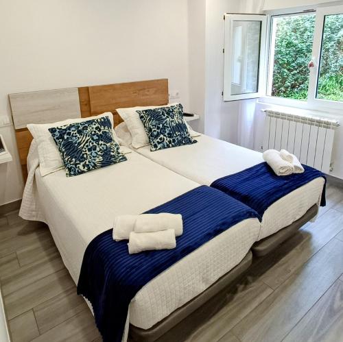 a bedroom with a large bed with towels on it at Las Gaviotas Cudillero in Cudillero