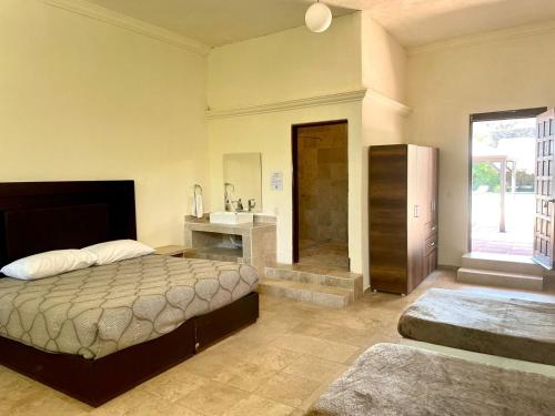 a bedroom with a bed and a bathroom with a shower at Jardin Zen in Tepoztlán