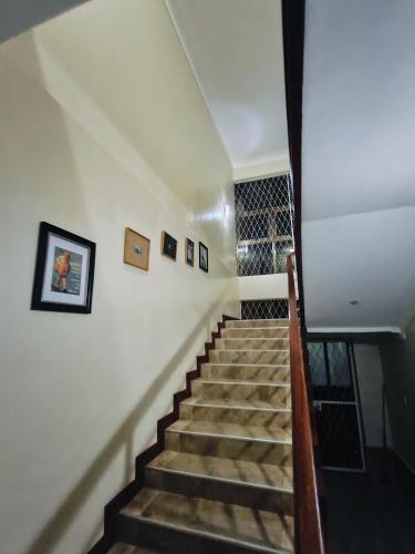 a stairway leading up to a building with pictures on the wall at Hidden beautiful Modern Apartment in Entebbe