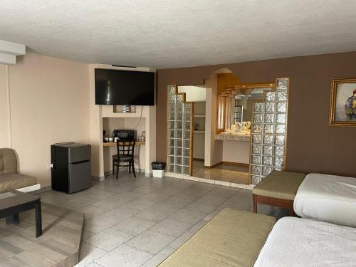 a room with a bed and a living room with a kitchen at Hotel Flamingo in Ciudad Juárez