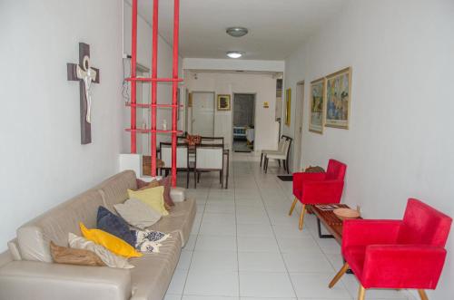 a living room with a couch and red chairs at Studio 51 residence in Recife