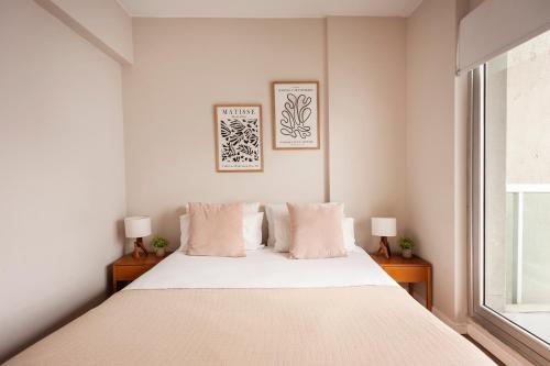 a white bedroom with a large bed with two lamps at Live & Enjoy Buenos Aires in Central Recoleta powered by Argenhost -A12J- in Buenos Aires