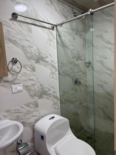 a bathroom with a shower and a toilet and a sink at Hotel Orduz Centro Histórico de Cali in Cali