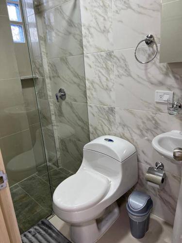 a bathroom with a toilet and a shower and a sink at Hotel Orduz Centro Histórico de Cali in Cali