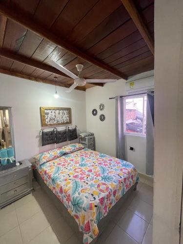 a bedroom with a bed with a colorful comforter at Casa 39-33 in Cartagena de Indias