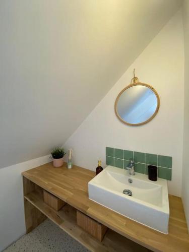une salle de bain avec un lavabo et un miroir dans l'établissement La maison Yvonne - bord de mer - Bénodet, à Bénodet