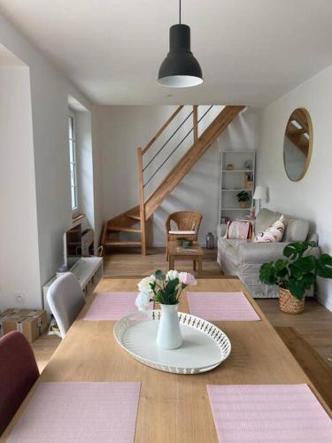 un salon avec une table avec un vase de fleurs dans l'établissement La maison Yvonne - bord de mer - Bénodet, à Bénodet