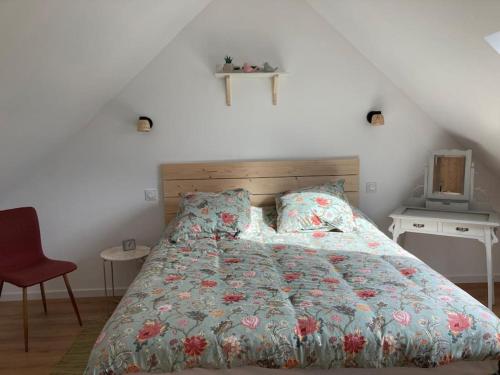 a bedroom with a bed and a red chair at La maison Yvonne - bord de mer - Bénodet in Bénodet