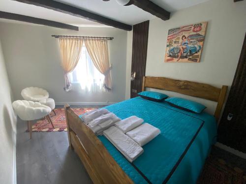 a bedroom with a blue bed with towels on it at İncirci Stone House, Sazlı Köyü in Ayvacık