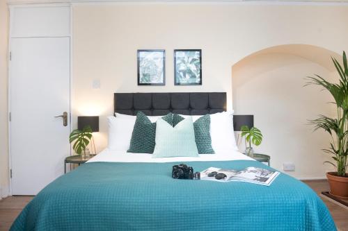 a bedroom with a large bed with a blue blanket at Wilson House - Camden in London