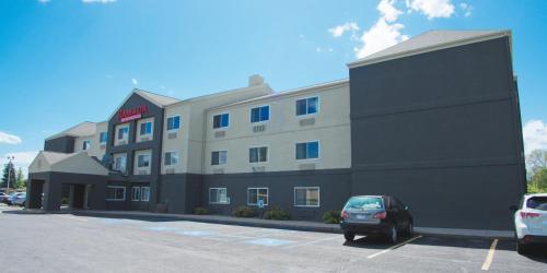 a building with a car parked in a parking lot at Ramada by Wyndham Coeur d'Alene in Coeur d'Alene