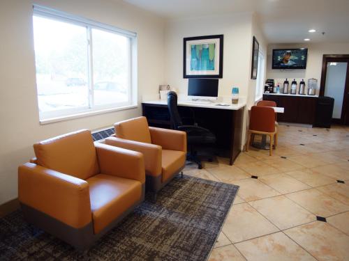 a office with a couch and chairs and a desk at Ramada by Wyndham Coeur d'Alene in Coeur d'Alene
