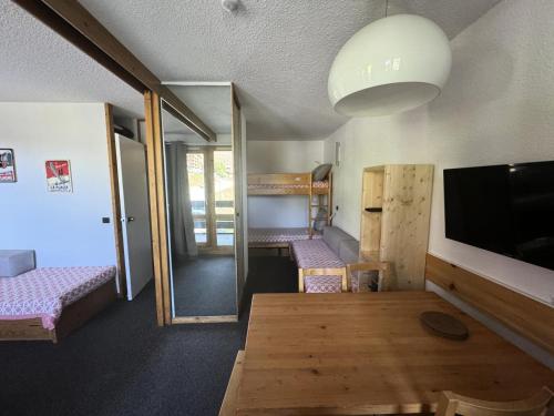 une chambre avec deux lits superposés et une télévision dans l'établissement Résidence Agate - Studio pour 4 Personnes 34, à Mâcot La Plagne