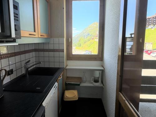une petite cuisine avec un évier et une fenêtre dans l'établissement Résidence Agate - Studio pour 4 Personnes 34, à Mâcot La Plagne