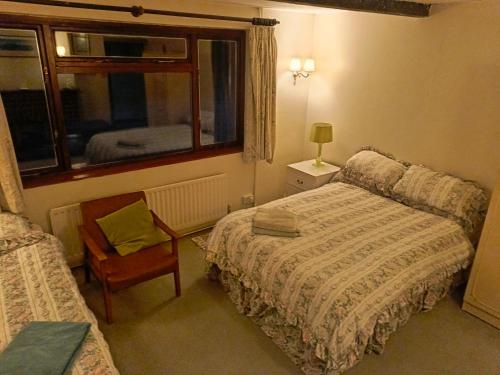 a bedroom with a bed and a chair and a window at Echoes in Battle