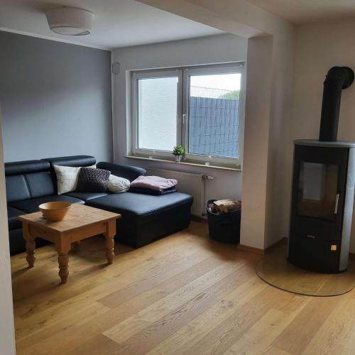 a living room with a couch and a wood stove at Bielsteiner Heideglück in Wiehl