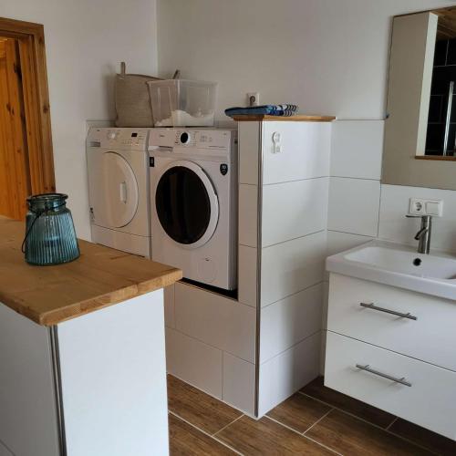 a kitchen with a washing machine and a sink at Bielsteiner Heideglück in Wiehl