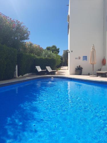 a large blue swimming pool next to a building at Rotonda Apartaments in Felanitx
