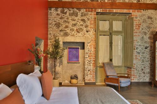 a bedroom with a bed and a chair and a window at CASA SAUTO11 Mexican architecture and design suite in Mexico City