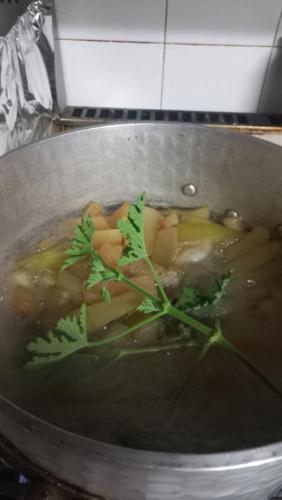 a pot of soup with vegetables and herbs in it at Guesthouse Selini in Vitsa
