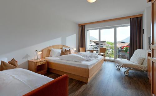 a hotel room with two beds and a balcony at Pension Apartment Hödner in Ebbs
