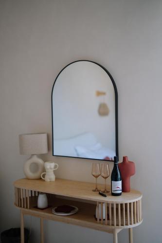 a mirror on top of a wooden table with wine glasses at Taga Suites in Catania