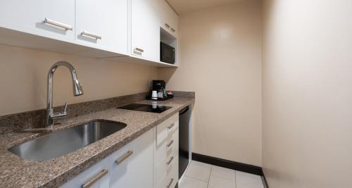 a kitchen with a sink and a counter top at Prestige Oceanview Hotel Prince Rupert in Prince Rupert