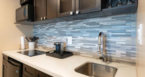 a kitchen with a sink and a counter top at Prestige Oceanview Hotel Prince Rupert in Prince Rupert