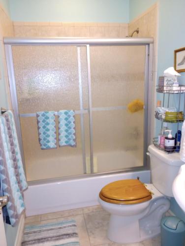 a bathroom with a shower with a wooden toilet at Isa's Nest in Pharr