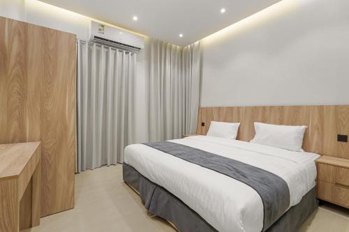 a bedroom with a large bed and a window at New Karam Suites in Riyadh