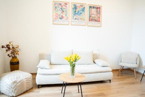 a living room with a couch and a table with flowers at Casa Lina in Trieste