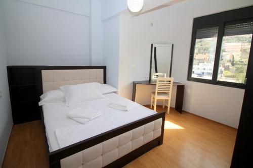 a bedroom with a bed and a desk and a chair at Motra Apartment in Metogjashta