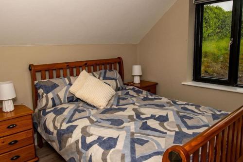 a bedroom with a bed with a comforter and a window at Sullcon Apartment in Killarney