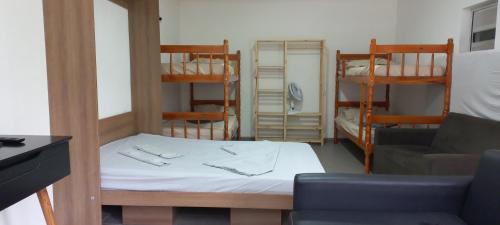 a room with a bed and a couch and bunk beds at Paz e descanso Chacara Meu Morrinho in Mairiporã