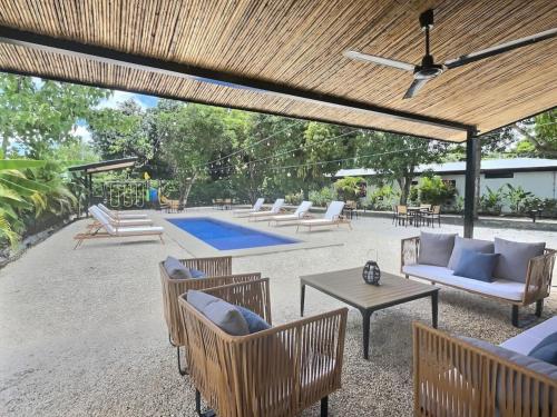 a patio with chairs and a table and a pool at Modern Villas in Tropical Community by Tamarindo in Villarreal