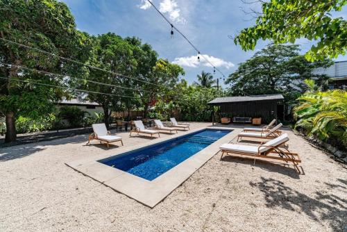 a pool with chaise lounge chairs and a group at Modern Villas in Tropical Community by Tamarindo in Villarreal