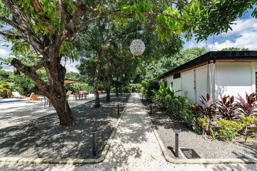 a sidewalk next to a building with a tree at Modern Villas in Tropical Community by Tamarindo in Villarreal