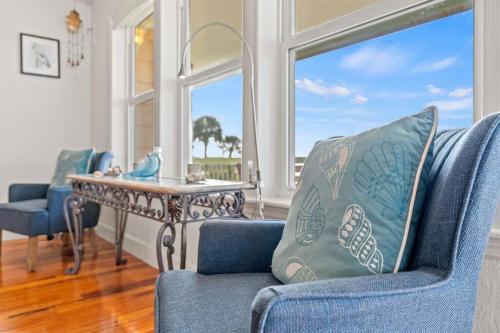 a living room with a table and blue chairs at Dolphin Cove Waterfront Home with Dock in Saint Augustine