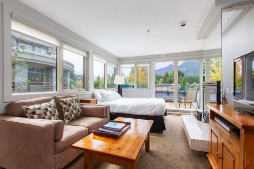 a living room with a couch and a bed at Village Gate House by Whiski Jack in Whistler