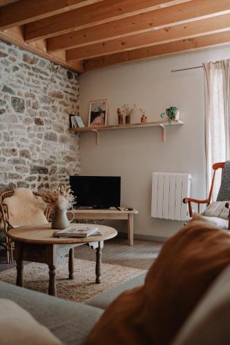 un salon avec un canapé et une table dans l'établissement Les Maisons du Tuly, au Tronchet