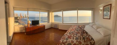 a bedroom with a large window with a view of the ocean at Islas del Sol in Mazatlán