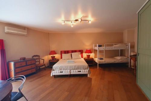 a bedroom with a bed and two bunk beds at Maison de Village en Camargue Parking Clim Wifi - ROSSIconciergerie - Linge inclus in Saint-Laurent-dʼAigouze